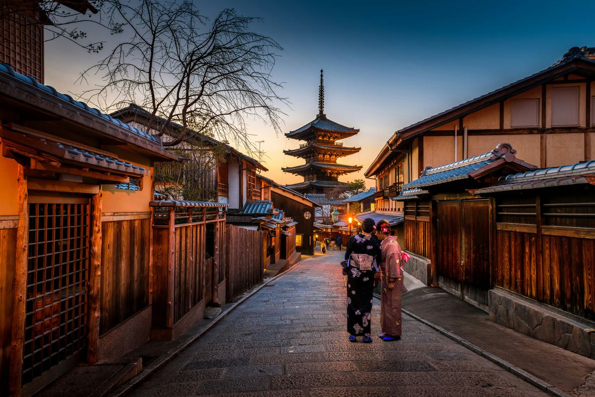 Fushimi Inari's red torii gates glowing under lantern light during a Kyoto evening festival